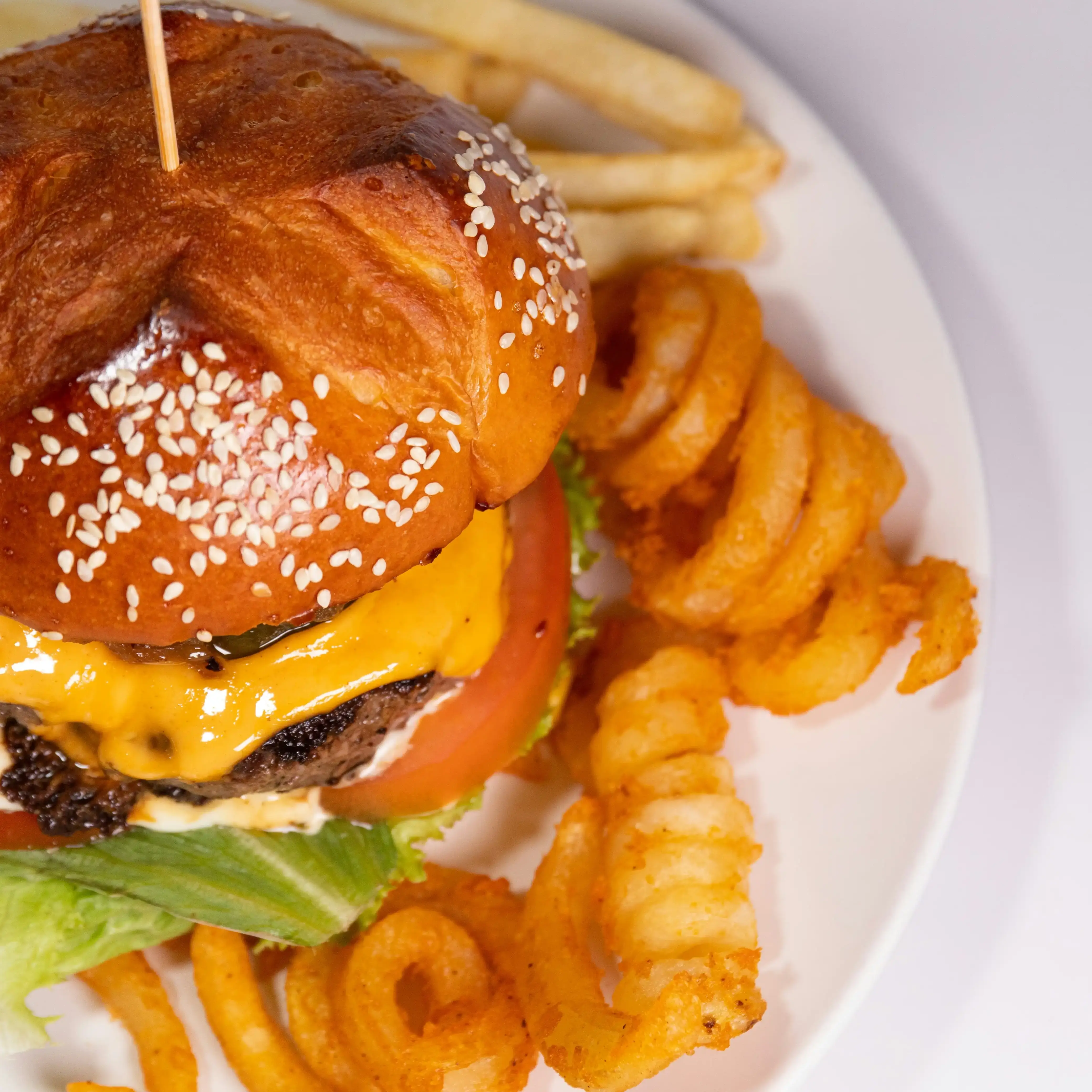 Curly fries served with a burger, showcasing fresh and frozen curly fries options